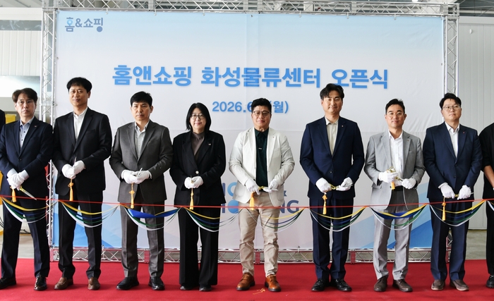 권진미 홈앤쇼핑 대표(왼쪽 네 번째), 김재진 홈앤쇼핑 경영부문장(왼쪽 세 번째),강병구 롯데글로벌로지스 대표(왼쪽 다섯 번째), 전태준 롯데 라스트마일 본부장(오른쪽 세 번째) 등 관계자들이 사진 촬영을 하고 있다. 〈자료:홈앤쇼핑〉