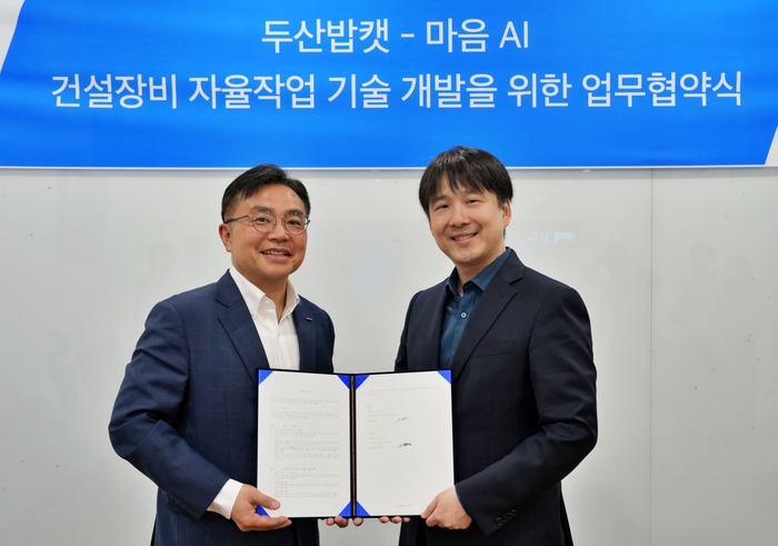 경기도 성남시 분당두산타워에서 열린 양해각서 체결식에서 박현철 두산밥캣 부사장(왼쪽)과 최홍섭 마음AI 대표가 기념 촬영을 하고 있다. 두산밥캣