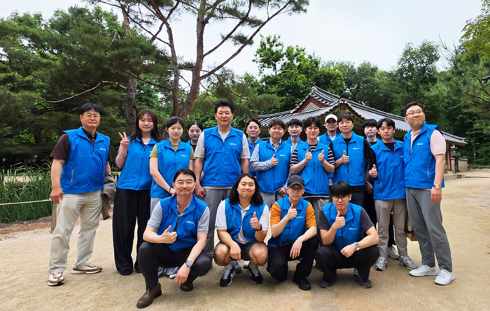 종묘 일대 문화유산 보존 봉사활동을 마친 뒤, 정삼용 대표이사(뒷줄 왼쪽 다섯 번째)와 김태욱 피플팀장(상무, 뒷줄 왼쪽 첫 번째) 등 임직원들이 기념 촬영을 하고 있다