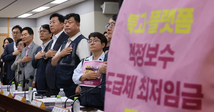 11일 정부세종청사 최저임금위원회에서 열린 제5차 전원회의에서 근로자위원과 사용자위원들이 국기에 경례하고 있다. 연합뉴스.