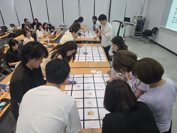13일 전남대에서 진행된 바우카 교구를 활용한 실습 활동 참가자들이 로봇 주행 면허증 프로그램을 시연해보고 있다. (사진=이티에듀)