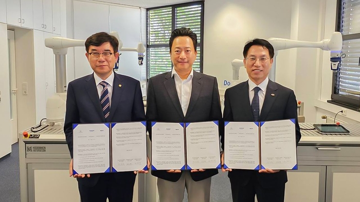 왼쪽부터 조영훈 한국로봇산업진흥원 원장, 유승박 두산로보틱스 유럽지사장, 노건기 한국전자기술연구원 원장이 20일(현지시간) 독일 프랑크푸르트 두산로보틱스 유럽지사에서 MOU를 교환하고 기념촬영하고 있다. 〈사진 KETI 제공〉
