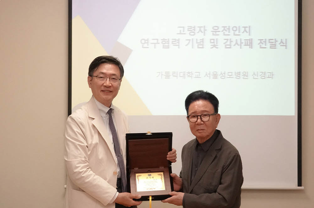 양동원 서울성모병원 신경과 교수(왼쪽)가 황규백 화백에게 감사패를 전달했다.