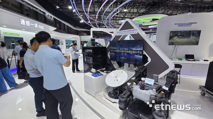 MWC26 상하이 CICT모바일 부스에서 관계자가 저고도 위성 안테나와 로봇 기술을 소개하고 있다.
