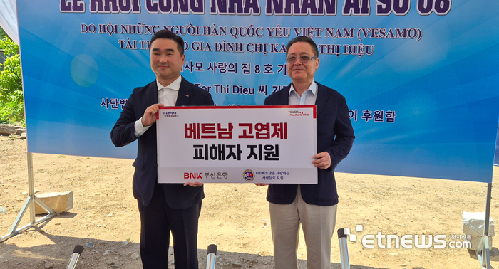 BNK부산은행은 지난 26일 베트남 나트랑에서 고엽제 피해 가정을 지원하기 위해 '사단법인 베트남을 사랑하는 사람들의 모임'에 미화 1만 달러의 성금을 전달했다. (왼쪽부터) 문동권 BNK부산은행 호치민지점장, 장호익 베사모 회장. [사진= BNK부산은행 제공]