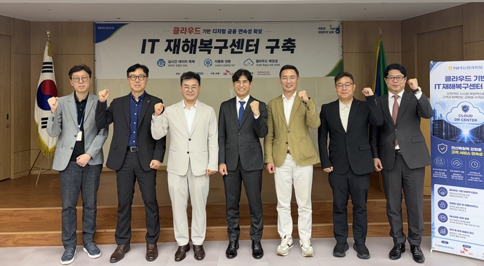 장종환 NH농협캐피탈 대표(왼쪽 세 번째), 신장수 SK AX 클라우드 부문장(왼쪽 네 번째), 위장영 오라클 클라우드 세일즈 부사장(오른쪽 세 번째)가 IT재해복구센터 구축 행사를 진행한 뒤 기념촬영을 하고 있다.