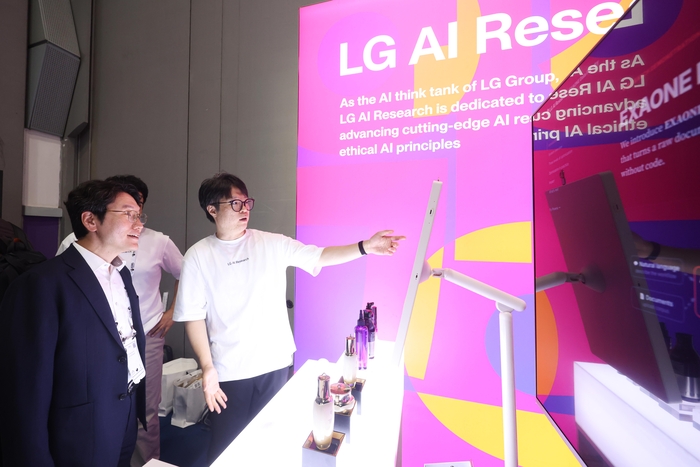 서울 코엑스에서 진행 중인 ICML 2026 LG AI연구원 부스에서 임우형 LG AI연구원 공동 연구원장(사진 왼쪽)이 탈모 관리 신소재 람시딜 설명을 듣고 있는 모습 사진제공=LG