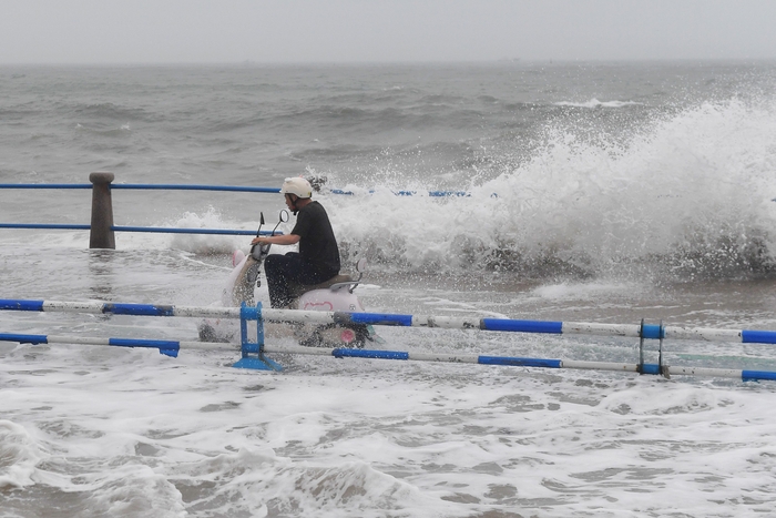 12일 태풍 바비가 상륙한 중국 칭다오(청두)에서 물에 잠긴 도로를 건너고 있는 스쿠터 운전자. 사진=AP 연합뉴스