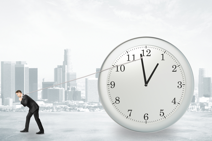 Businessman trying to return the time with rope, stop the time concept
