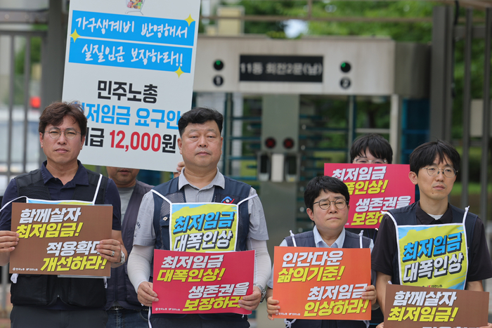 최저임금위원회 제14차 전원회의가 열리는 14일 한국노동조합총연맹(한국노총)과 전국민주노동조합총연맹(민주노총) 조합원들이 정부세종청사 최저임금위원회 앞에서 기자회견을 열고 있다. 연합뉴스.