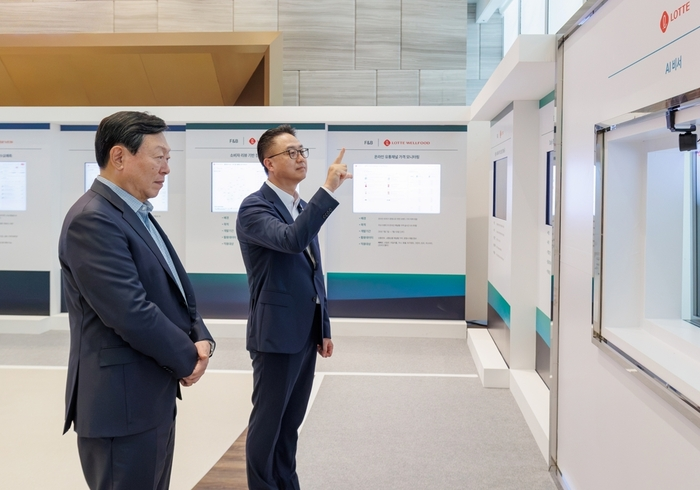 신동빈 롯데 회장(왼쪽)이 황민재 롯데지주 경영혁신실장(오른쪽)으로부터 음성과 모션 인식 기반 'AI 비서'에 대한 설명을 듣고 있다. 자료:롯데