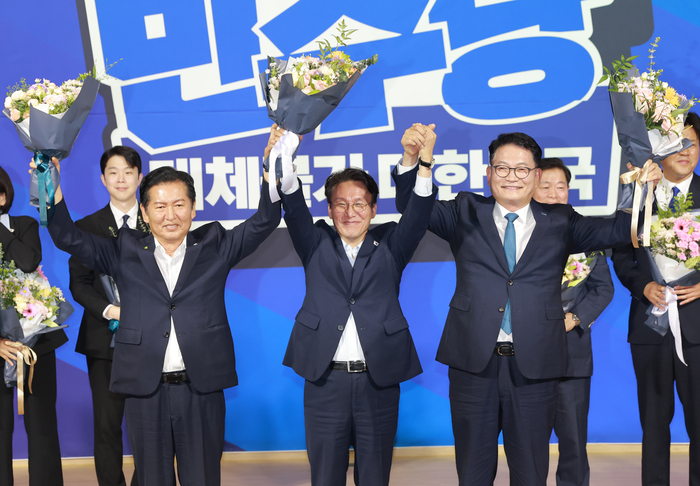더불어민주당 당 대표 예비경선을 통과한 정청래(왼쪽부터), 김민석, 송영길 후보가 23일 국회 의원회관에서 당 대표·최고위원 예비경선 결과 발표 뒤 단상에 올라 기념 촬영하고 있다. 연합뉴스
