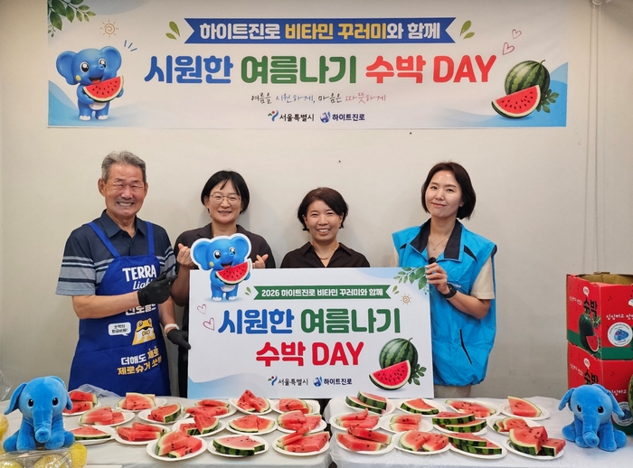 지난 22일 서울역 쪽방촌에서 2026 하이트진로 비타민 꾸러미와 함께 시원한 여름나기 '수박 DAY' 행사가 열렸다. (왼쪽부터) 쪽방촌 주민, 서울시 이신옥 팀장, 서울역 쪽방상담소 유호연 소장, 하이트진로 관계자가 기념 촬영을 하고 있다. 〈자료 하이트진로〉