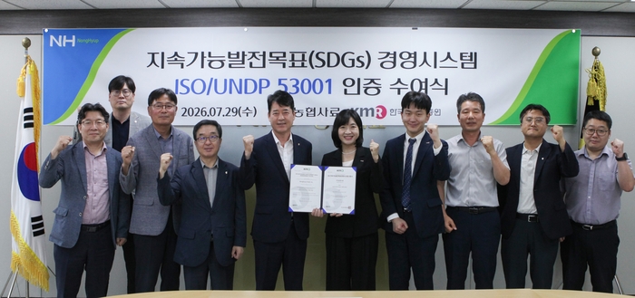 최강필 농협사료 대표이사(왼쪽 다섯 번째)와 황은주 한국경영인증원 대표이사(여섯 번째)가 '지속가능발전목표 경영시스템(ISO/UNDP 53001)' 국제 인증 수여식에서 관계자들과 기념촬영을 하고 있다. (사진=농협사료)