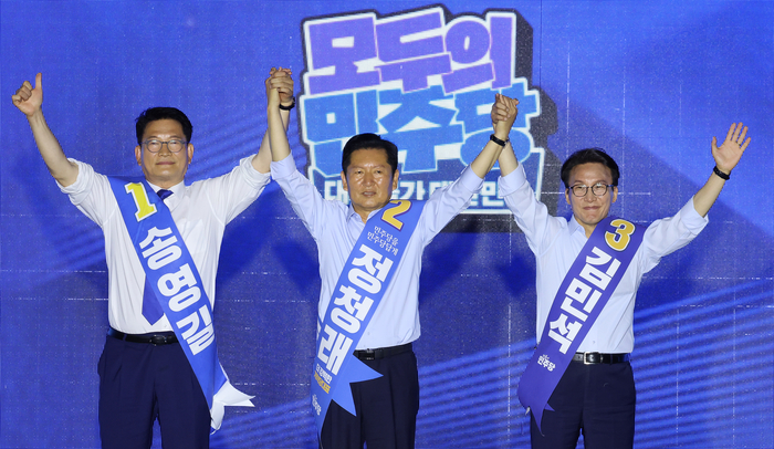 송영길, 정청래, 김민석(기호순) 당 대표 후보가 2일 부산 벡스코에서 열린 더불어민주당 당대표·최고위원 순회경선 합동연설회에서 손을 맞잡아 올리고 있다. 〈연합뉴스〉