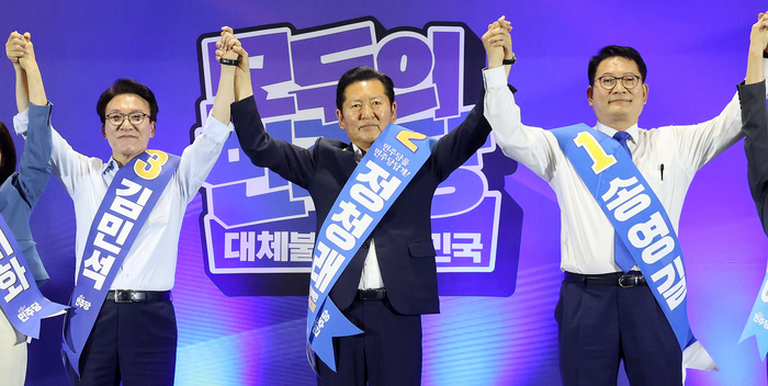 더불어민주당 김민석(왼쪽부터), 정청래, 송영길 당 대표 후보가 2일 울산전시컨벤션센터에서 열린 당 대표·최고위원 순회경선 합동연설회에서 손을 맞잡아 올리고 있다. 연합뉴스