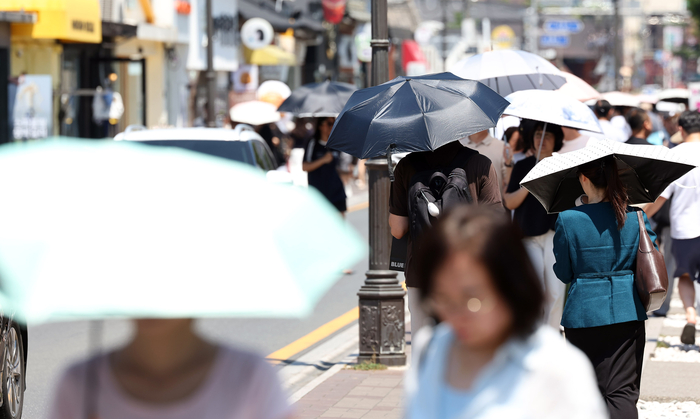 폭염 중대경보가 내려진 경북 경주시에서 더위를 피해 양산을 쓰고 걷고 있는 시민들. 사진=연합뉴스
