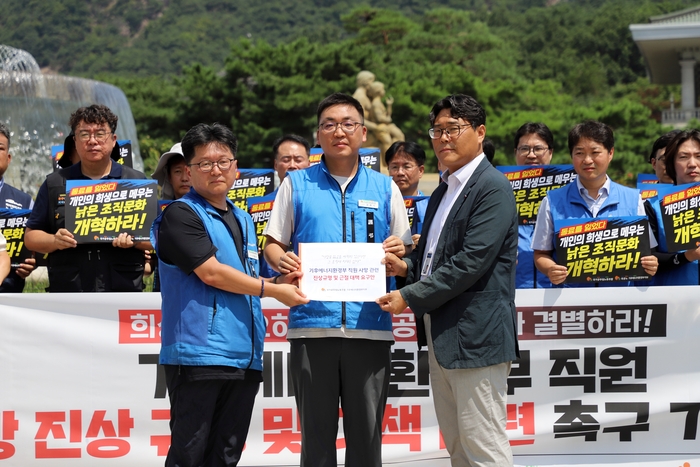 은준기 국가공무원노동조합 기후에너지환경부 지부위원장(가운데)과 이철수 국공노 위원장(왼쪽)이 청와대 관계자에게 구조적 과로 근절 및 진상규명 촉구 성명서를 전달하고 있다. 사진 출처 : 국공노