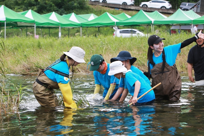 8월 1일 강원도 화천군 화천읍에서 에쓰오일 봉사활동 참가자들이 황쏘가리 치어를 방류하고 있다.
