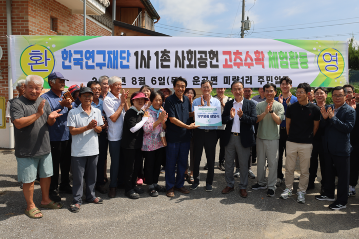 이석래 연구재단 사무총장(앞줄 가운데) 등 연구재단 임직원과 백월산마을 주민 간 물품 기부식이 진행되는 모습. (연구재단 제공)