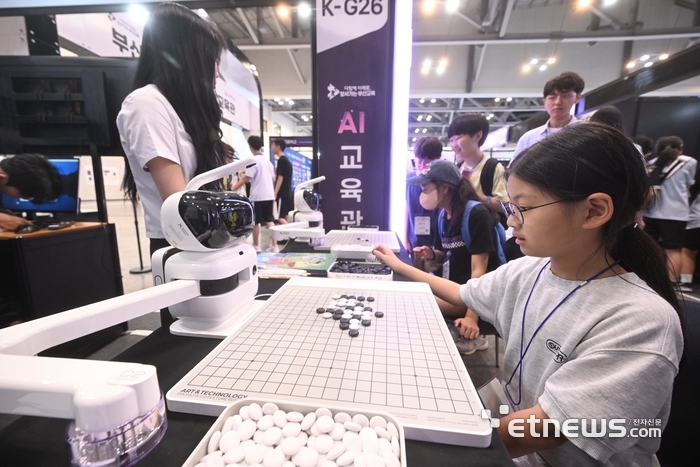 지난해 'K-ICT 위크인부산' 전시장에서 학생 관람객이 AI와 바둑을 두고 있다.