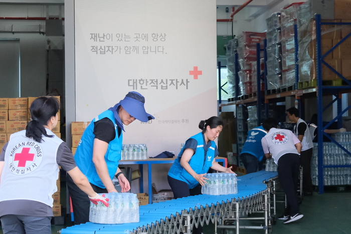 11일 서울 양천구 대한적십자사 재난안전센터에 상미당홀딩스 해피봉사단이 폭염 피해 지역 지원을 위한 생수를 전달하고 있다. 〈자료 상미당홀딩스〉