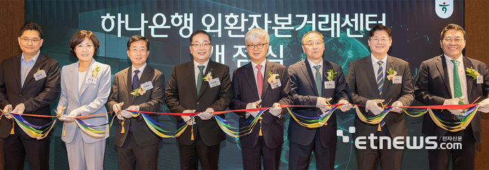 하나은행은 지난 11일 서울 강남구 삼성동 소재 Place1 4층에 기업과 자산가의 다양한 국제 금융 수요에 전문적으로 대응하기 위한 외환 특화 조직 '외환자본거래센터'를 개점했다. 이호성 하나은행장(왼쪽에서 네 번째), 이동훈 법무법인 바른 대표변호사(왼쪽에서 세 번째), 강석훈 법무법인 율촌 대표변호사(왼쪽에서 다섯번째)와 관계자들이 테이프 커팅식을 진행하며 기념 촬영을 하고 있다. [사진= 하나은행 제공]