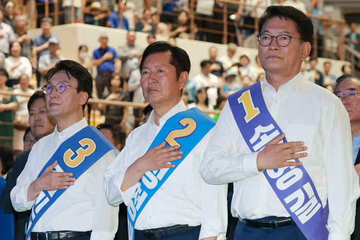 더불어민주당 김민석·정청래·송영길 당 대표 후보가 15일 전남광주 나주시 나주종합스포츠파크 다목적체육관에서 열린 민주당 대표·최고위원 전남광주 합동연설회에 참석해 국기에 경례하고 있다. 연합뉴스