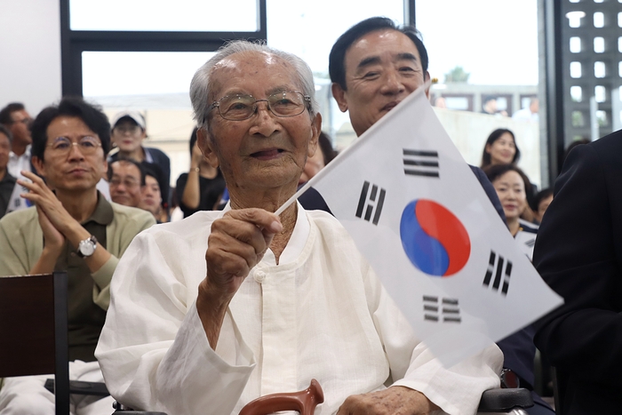 지난 15일 제주도 서귀포시 성산읍 시흥리에서 열린 '광복잇길' 행사에 참석한 강태선 애국지사가 태극기를 흔들고 있다. (사진=자생한방병원)