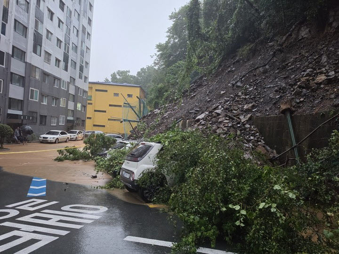 거제시 한 주택가에서 발생한 산사태로 흘러내린 토사가 차량을 덮쳤다. 사진=경남소방본부