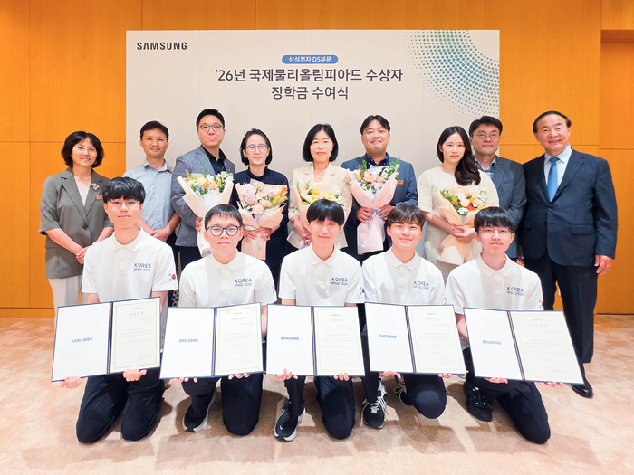 전영현 삼성전자 DS 부문장 부회장(뒷줄 오른쪽)과 윤진희 한국물리학회장(뒷줄 왼쪽), 올해 국제물리올림피아드 수상자들(앞줄 전원)과 학부모 등이 삼성전자 화성캠퍼스에서 열린 장학금 수여식에 참석해 기념 촬영하고 있다.