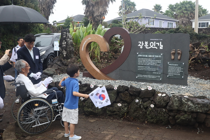 지난 15일 제주도 서귀포시 성산읍 시흥리에서 열린 '광복잇길' 기림비 제막식에서 자생의료재단 신민식 사회공헌위원장이 강태선 애국지사에게 광복잇길 기림비에 대해 설명하고 있다. (사진=자생한방병원)
