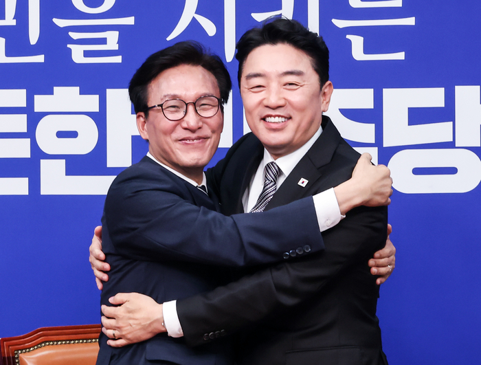 더불어민주당 김민석 대표(왼쪽)가 18일 국회에서 취임 축하 인사차 방문한 강훈식 대통령비서실 비서실장을 만나 반갑게 포옹하고 있다. 연합뉴스