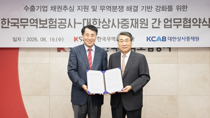 장영진 한국무역보험공사 사장(왼쪽)과 신현윤 대한상사중재원 원장(오른쪽)이 업무협약 체결 후 기념 촬영을 하고 있다. (사진=한국무역보험공사)
