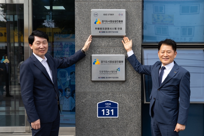 엄진엽 중소벤처기업인증원 원장(오른쪽)과 김민철 경기도시장상권진흥원 원장이 ISO 37001 인증현판 부착식 후 함께 기념촬영을 하고 있다.