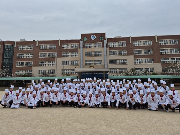 평촌경영고 식품, 외식 조리부문 재학생들이 학교 본관을 배경으로 단체 촬영했다. 〈평촌경영고 제공〉