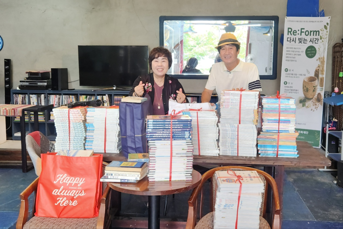 박재용 오오작은도서관 관장(오른쩍)과 이소현 전남광주통합특별시 민원메신저 대표가 아동도서 및 단행본 헌책 500여 권을 기증식을 가진 뒤 기념촬영하고 있다.