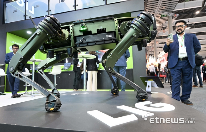 MWC2026 LIG아큐버 부스에서 관람객이 정찰, 탐지 기능을 탑재한 자율주행 사족보행로봇을 살펴보고 있다. 바르셀로나(스페인)=김민수기자 mskim@etnews.com