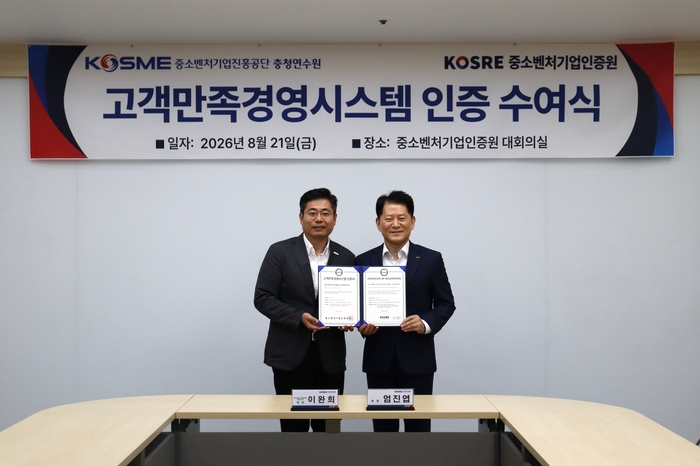 엄진엽 중소벤처기업인증원 원장(오른쪽), 이완희 중진공 충청연수원 원장이 ISO 10002(고객만족경영시스템) 인증 수여식 후 함께 기념촬영을 하고 있다.