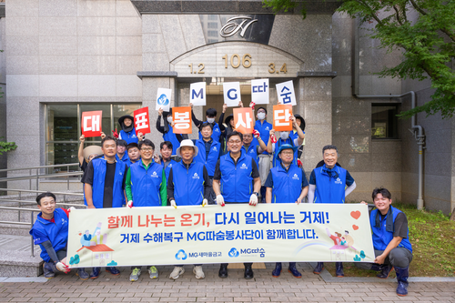 24일 MG따숨봉사단이 거제시 수해 현장에서 복구 지원 활동을 진행하고, 기념촬영을 하고 있다.(사진=새마을금고)
