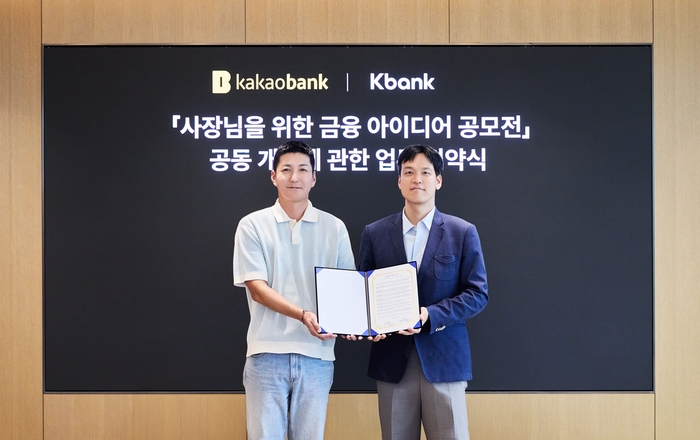 카카오뱅크 김성수 여신본부장(오른쪽)과 케이뱅크 김민찬 Corporate그룹장(왼쪽)이 지난 28일 경기도 성남시 카카오뱅크 판교오피스에서 진행된 '사장님을 위한 금융 아이디어 공모전' 업무협약식에 참여해 기념촬영을 하고 있다.