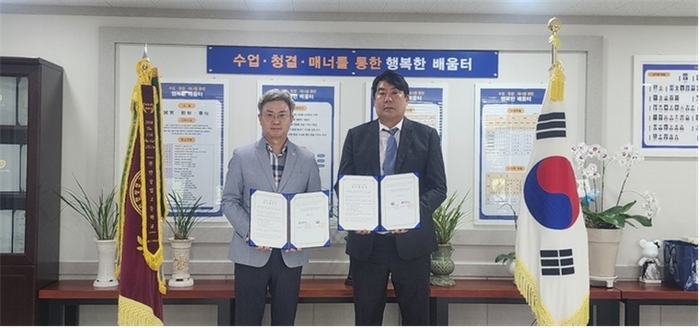박광래 천안상고 교장(왼쪽)과 정동화 상명대 대학일자리본부장이 협약서 교환 뒤 이를 펼쳐보이고 있다. 〈상명대 제공〉