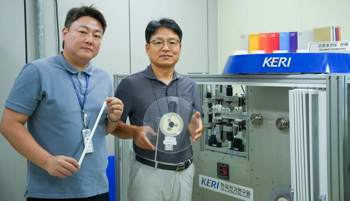 한국전기연구원 극저온기기연구센터 하홍수(오른쪽), 박인성 박사가 고온초전도 소재를 들고 3D 비접촉 초정밀 검사 장비 옆에서 포즈를 취했다.