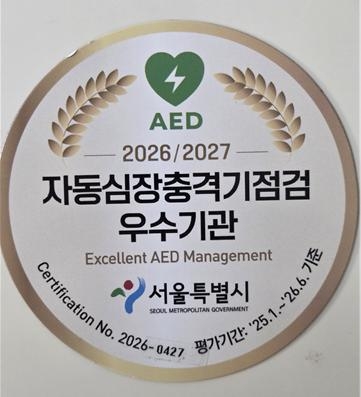 한성대학교 교내 체육관 앞 자동심장충격기(AED) 설치대에 부착된 서울특별시 '자동심장충격기점검 우수기관' 인증 스티커