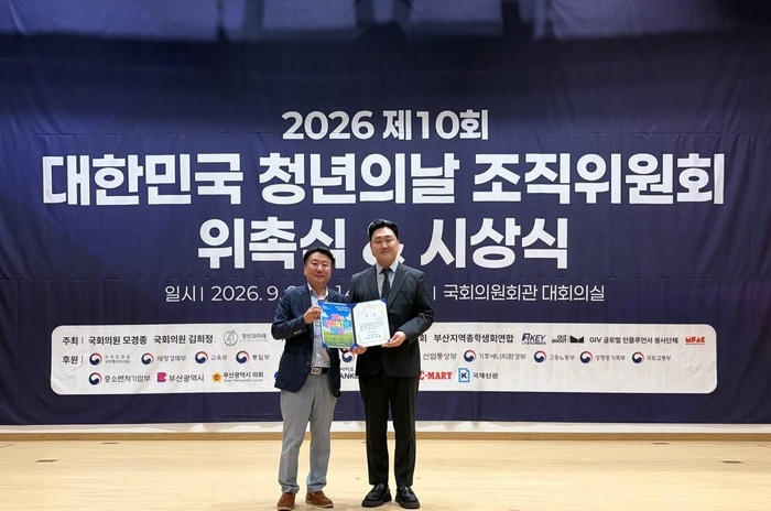 박태랑 쿠팡 사회공헌실 부장(오른쪽)이 정현곤 청년과미래 이사장으로부터 국회 보건복지위원장상을 받고 사진 촬영을 하고 있다.