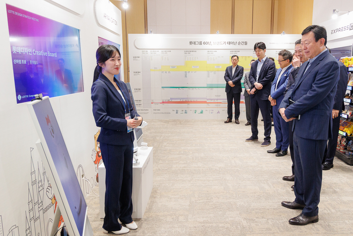 롯데는 10일 롯데월드타워에서 '2026 롯데 디자인전략회의'를 개최했다. 신동빈 롯데 회장(오른쪽 첫번째)이 젊은 디자이너들의 AI 프로젝트 결과물인 '로티로리 로봇 롯데월드 안내 서비스'에 대한 설명을 듣고 있다.
