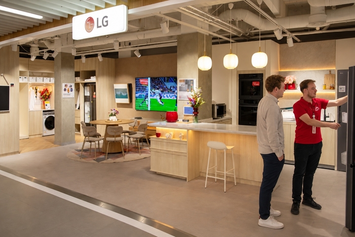 네덜란드 로테르담에 위치한 전자제품 매장 '미디어마크트 테크빌리지 로테르담'의 LG전자 매장에서 직원이 고객과 대화 중인 모습. 약 22평 규모의 매장 안에는 주방, 거실, 다용도실 등 유럽 생활 환경을 배경으로 다양한 고효율 가전제품이 전시돼 있으며, LG 씽큐(ThinQ)와 연계한 호미(Homey) 중심의 AI홈 솔루션 체험도 가능하다.  사진제공=LG전자