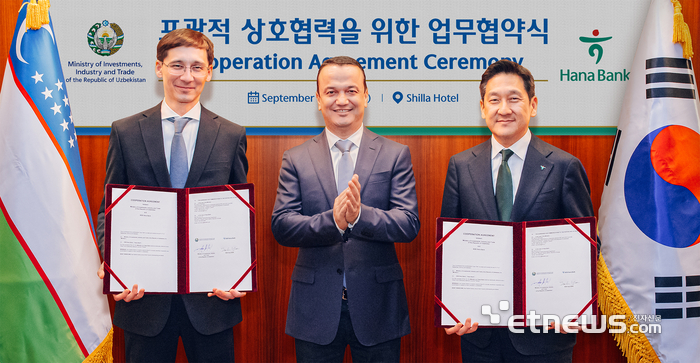 하나은행은 지난 11일 우즈베키스탄 투자산업통상부와 투자·금융 협력을 위한 업무협약을 체결했다. 이날 협약식에 참석한 윤태선 하나은행 글로벌사업본부 본부장(오른쪽)이 라지즈 쿠드라토프 우즈베키스탄 투자산업통상부 장관(가운데), 굴라모프 우즈베키스탄 투자산업통상부 차관(왼쪽)과 함께 협약서를 들고 기념 촬영을 하고 있다. [사진= 하나은행 제공]