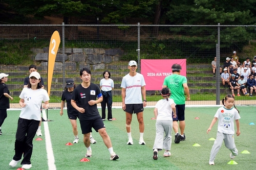 12일 서울어린이대공원에서 진행된 AIA 트랙 데이 행사에서 AIA생명 헬스앤웰니스 앰배서더 션(가운데)가 참가자들과 트레이닝을 진행하고 있다.(사진=AIA생명)