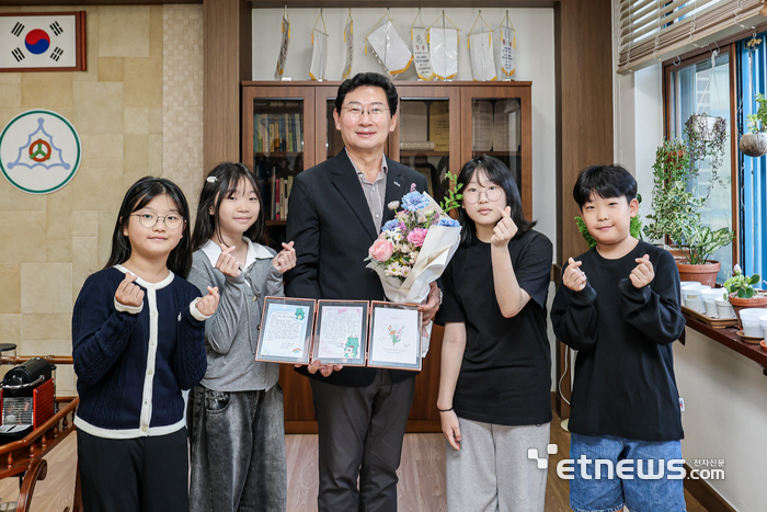 이상일 용인시장이 16일 시의 예산을 투입해 미래형 과학실로 탈바꿈한 서원초에서 학생들에게 감사의 손편지를 전달받고 기념 촬영했다. 용인시 제공.